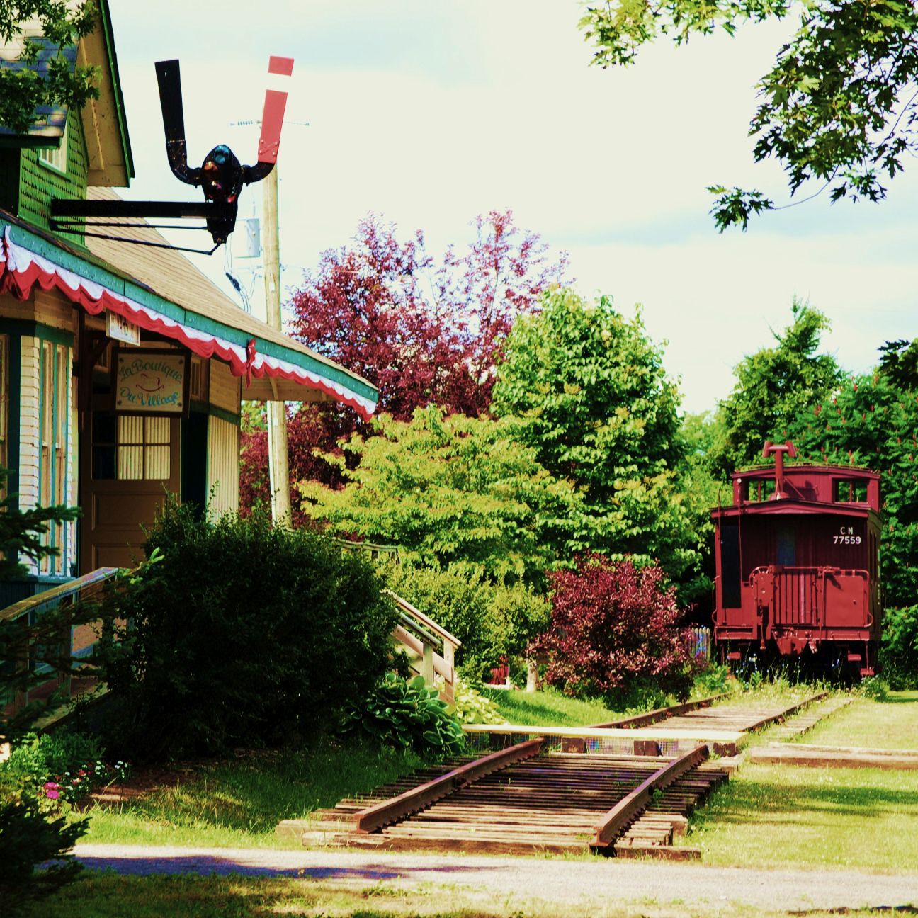 Exterior view of the former Vars train station and a red caboose.